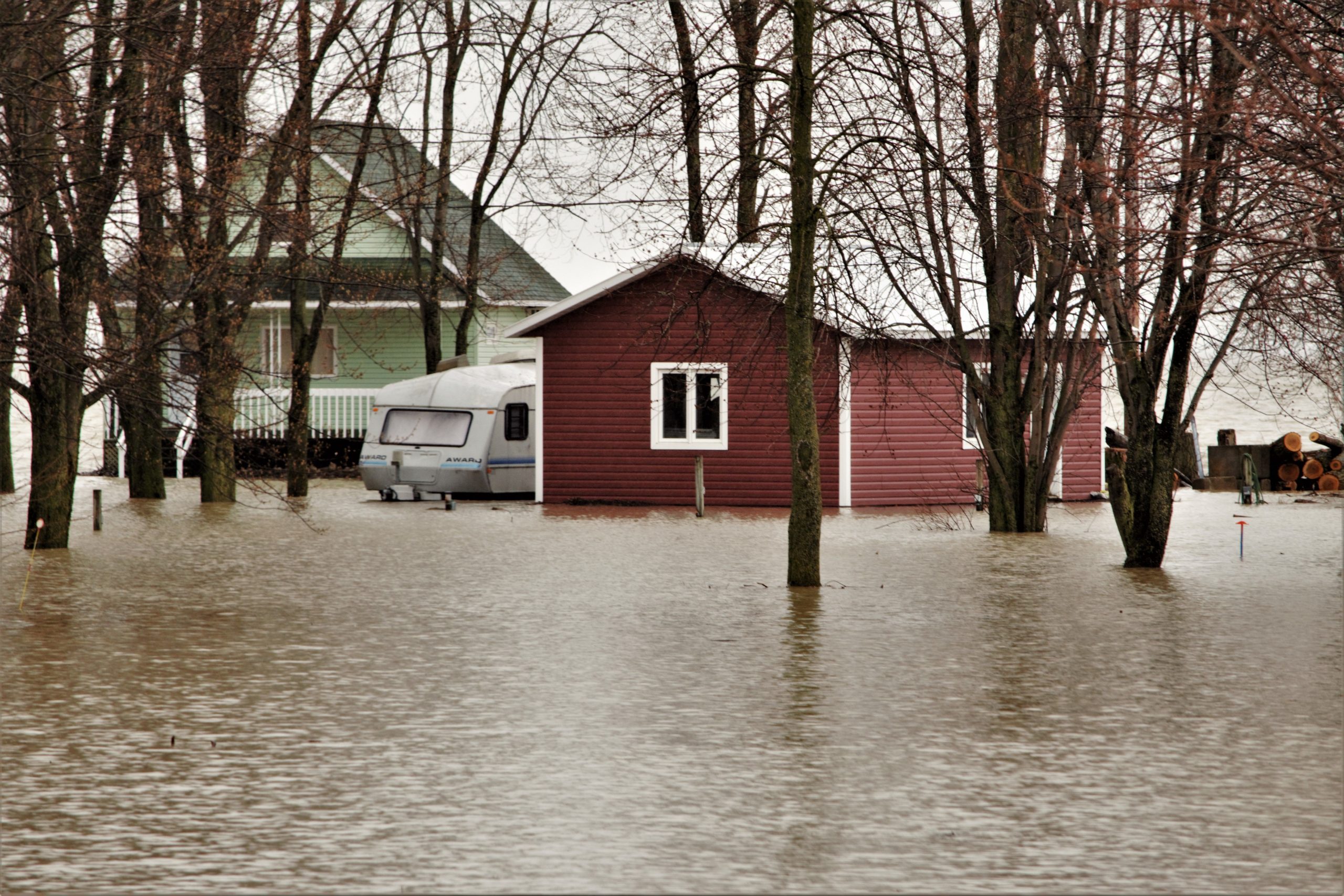A house and caravan surrounded by floodwaters, illustrating the loss of home to disaster