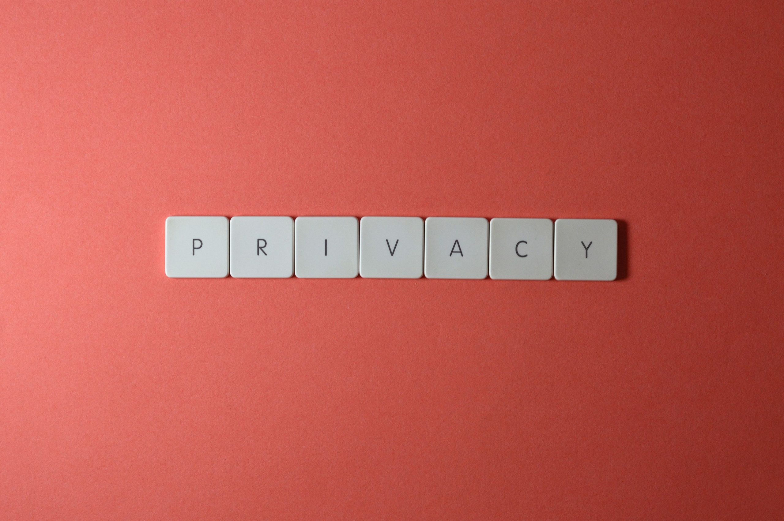 Letter tiles spelling PRIVACY on a red background, symbolizing data protection and the rising value of personal privacy