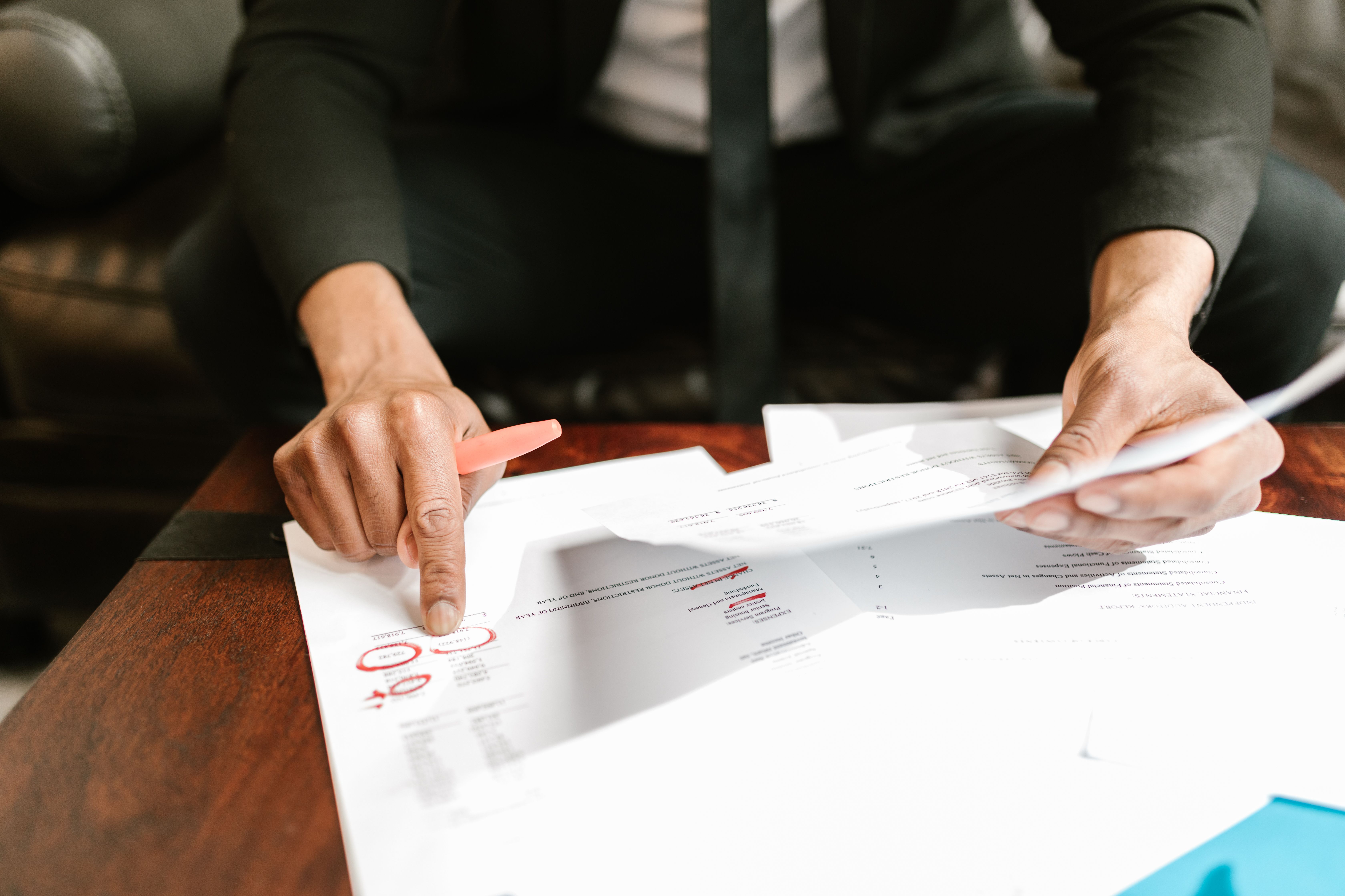 A businessman analyzing financial documents with data and figures on a desk